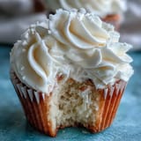 Vanilla cupcakes topped with elegant white fondant cross decorations, perfect for celebrating a First Communion with family and friends.  