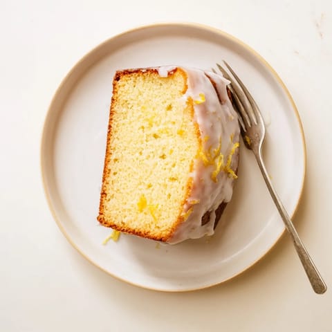 Freshly baked Lemon Pound Cake with a moist, dense crumb and sticky lemon glaze dripping down the sides.