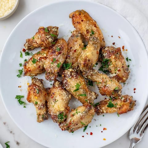 Golden brown, crispy Garlic Parmesan Wings fresh from the oven, tossed in garlic butter and parsley.