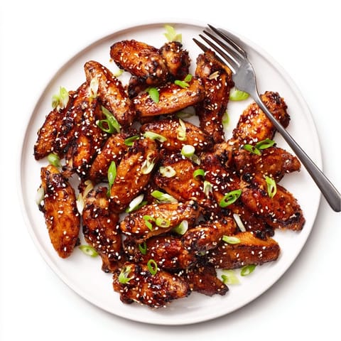 Succulent Asian Sticky Wings fresh from the oven, sticky and caramelized, ready to be served with steamed rice.