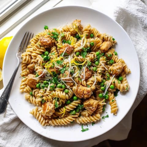A family-friendly Garlic Butter Chicken & Pea Pasta shines with golden chicken, bright peas, and a light lemony sheen on the noodles.  