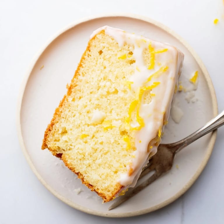 Close-up of a glazed Lemon Pound Cake showing the tender, buttery texture and zesty lemon topping.