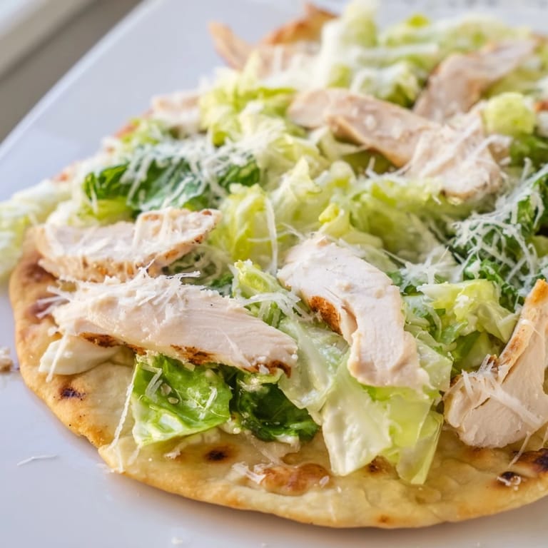 Sizzling grilled chicken layered on Chicken Caesar Flatbread with cherry tomatoes and parmesan.