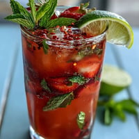 Vibrant strawberry chili limeade mocktail glistening with fresh fruit and a spicy kick.